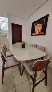 锡诺普Apartamento Confortável e Espaçoso的一间配备有白色桌椅的用餐室