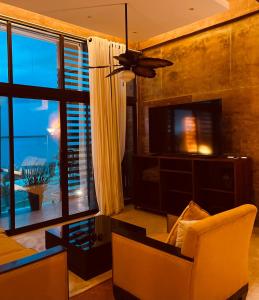 切图马尔Hotel "ala Residencias"的客厅配有吊扇和电视。