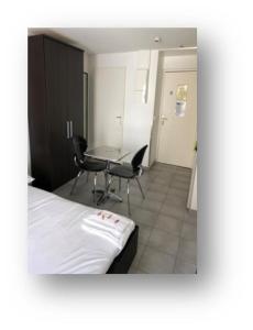 格勒诺布尔帕特里夏公寓酒店的卧室配有一张床和一张桌子及椅子