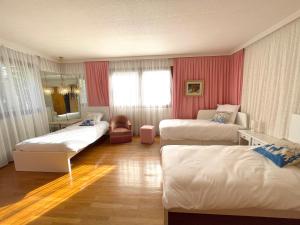 比埃什河畔阿斯普尔Villa Caprice à l'orée des bois的酒店客房设有两张床和窗户。