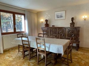 比埃什河畔阿斯普尔Villa Caprice à l'orée des bois的一间带桌椅和窗户的用餐室