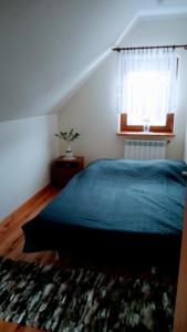 Enklawa Spokoju的一间卧室设有蓝色的床和窗户。