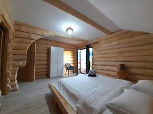 博尔沙CABANA BELVEDERE的一间设有白色床的卧室,位于带木墙的房间