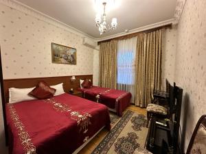 塔什干Sarbon Hotel Tashkent的酒店客房设有两张床和吊灯。