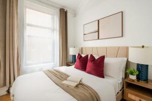 纽约139-2W Prime west village Furnished 2BR Best value的卧室配有带红色枕头的大型白色床