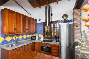 托罗克斯Villa Benizan的厨房配有木制橱柜和不锈钢冰箱。