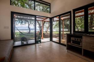 普拉纳维瑙Body - Tiny Home Venao Cove的客厅设有滑动玻璃门和吊床