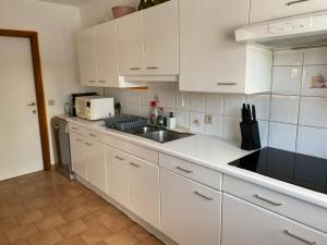 斯滕奥克尔泽尔Perk25A的厨房配有白色橱柜和水槽