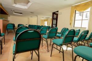 巴兰基亚Hotel Caribe Plaza Barranquilla的一间空房间,教室里摆放着绿色椅子