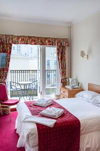 伊斯特布恩埃弗顿酒店的酒店客房,配有一张带红色毯子的床