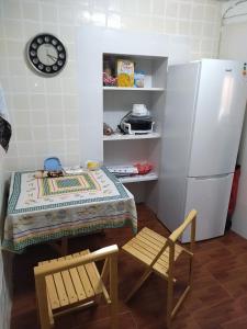 卡塔赫纳Habitación hippie的厨房配有桌椅和冰箱。