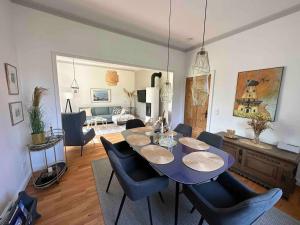 WesterholzLandhaus Oscar (150m zum Strand)的一间配备有蓝色桌子和椅子的用餐室