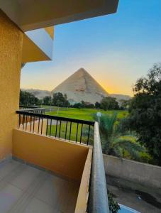 开罗Glamour Pyramids Hotel的从大楼的阳台上可以欣赏到金字塔的景色