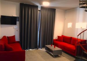 诺亚福克Aurora Suites的客厅配有红色沙发和电视