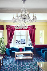 伊斯特布恩埃弗顿酒店的客厅配有蓝色家具和吊灯。