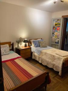 萨尔托hoStel 3B Hab Central Baño Privado externo y Aire ac的一间卧室配有两张床和床头灯。