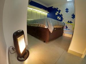 库里提巴Family House - Curitiba的卧室配有一张床,地板上光线充足