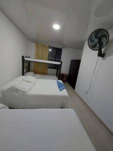 伊瓦格Cómoda casa de campo的卧室配有两张床,墙上配有风扇