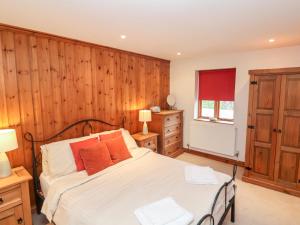 Rousdon3 Home Farm South的一间卧室设有一张床和木墙