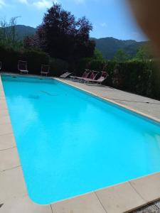 库尼奥Agri BERTORELLA的一个带两把草坪椅的大型蓝色游泳池