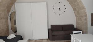 莫拉-迪巴里Dimora Gassi的客厅配有沙发和墙上的时钟