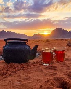 瓦迪拉姆Moon city camp的沙漠里的茶壶和两杯