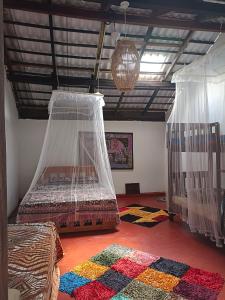 哈伯勒内Mamisa Café, Home stay的一间卧室配有带蚊帐的床铺和地毯。