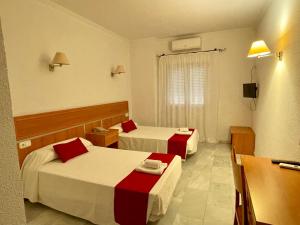 帕洛斯德拉夫龙特拉Hotel Puerto de Palos (La Rabida)的酒店客房设有两张床和电视。