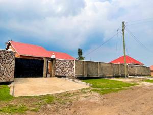 KisoroAgape House的一座红色屋顶和栅栏的建筑
