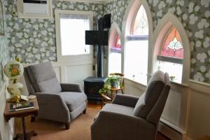 巴港Black Friar Inn and Pub的客厅配有两把椅子和两扇窗户