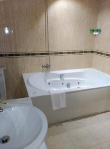 圣西普安－德比尼亚斯圣西伯来酒店的浴室配有白色浴缸和卫生间。