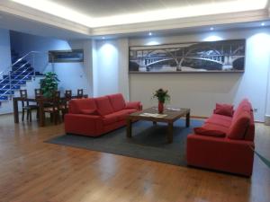圣西普安－德比尼亚斯圣西伯来酒店的客厅配有2把红色椅子和桌子