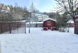 图尔库Cozy 93m² Townhouse with Large Terrace & Sauna的雪覆盖的院子,围着栅栏和棚子