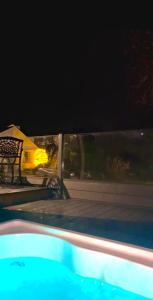 纽里Tanglewood Loft的夜间游泳池,带长凳和房子