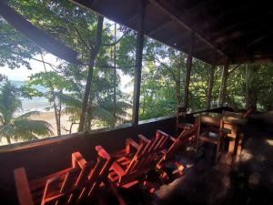 德雷克Pirate Drake Beach Camp & Tour company的配有椅子和桌子的客房,享有海滩美景