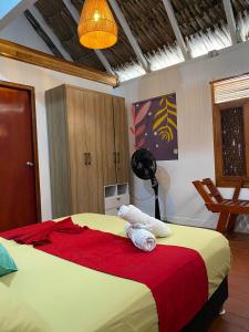 格兰德岛Isla Los Erizos EcoHouse的一间卧室配有一张带红色毯子的大床