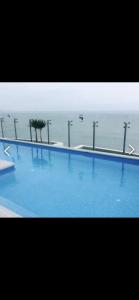 利马Panoramic Condominio的一个大型的游泳池,背景是大海