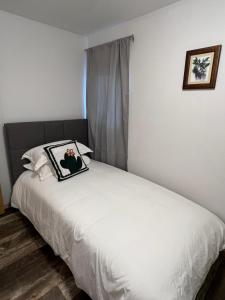 怀特霍斯Entire House and Home in Whitehorse Downtown的卧室配有一张白色的床,上面有照片