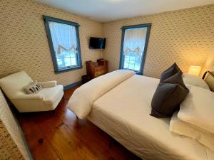 WaitsfieldThe Griff Inn的一间卧室配有一张床、一把椅子和窗户。