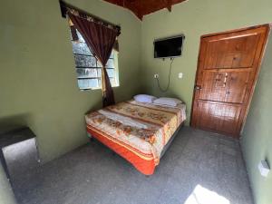 帕纳哈切尔Cabaña de Atitlan的卧室配有床、电视和门