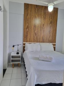巴西利亚Residencial Green Park的卧室配有白色的床和木墙