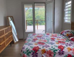 拉特里尼泰Villa Cannelle -charmante et tout confort的一间卧室配有一张带花卉棉被的床和窗户。