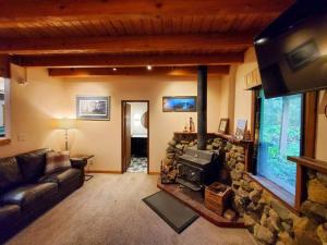 朱诺Juneau Cabin near Eaglecrest & Trails的带沙发和石制壁炉的客厅