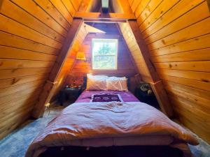 朱诺Cabin & A-Frame w/ Firepit near Fishing & Trails的木制阁楼卧室配有一张床