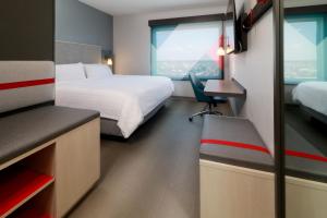 提华纳avid hotels - Tijuana - Otay, an IHG Hotel的酒店客房设有一张床、一张书桌和窗户。