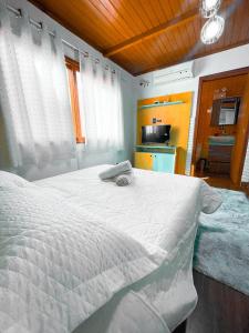 里奥格兰德Magic house banheira de hidromassagem e piscina的一间带白色床的卧室和一间厨房