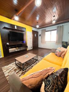 里奥格兰德Magic house banheira de hidromassagem e piscina的客厅配有黄色的沙发和桌子