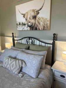 拉瑟格伦Charming 3 bedroom wine country cottage的一间卧室,卧室里配有一张带公牛照片的床