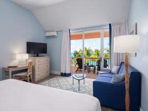 Southampton珊瑚礁俱乐部度假村的酒店客房设有床、沙发和阳台。