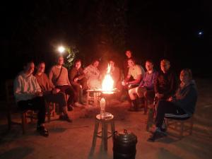 Ban NongkhamNongKhiaw CampingSite Swimming Pool的一群人晚上坐在火炉旁